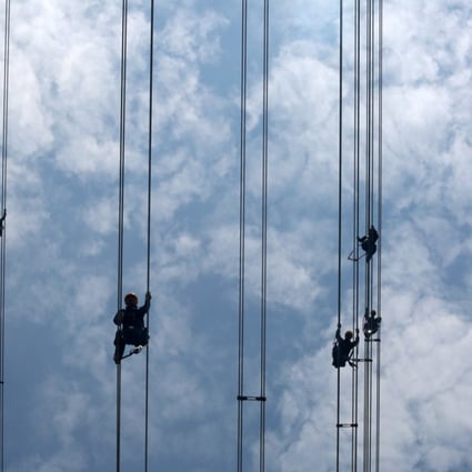 China Southern Power Grid workers inspect power cables connecting transmission towers in Dongguan, Guangdong province, on May 29. Chinese electricity demand is projected to grow 2.5 per cent by 2020. Photo: Reuters