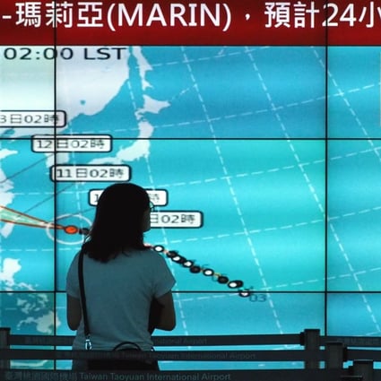 A woman looks at a display with a typhoon chart at Taoyuan International Airport in Taiwan. Super typhoon Maria was heading towards the island on Tuesday morning and as expected to hit the north the hardest. Photo: EPA-EFE