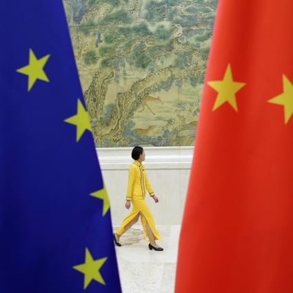 An attendant walks past EU and China flags ahead of the EU-China High-level Economic Dialogue in Beijing on June 25. Photo: Reuters