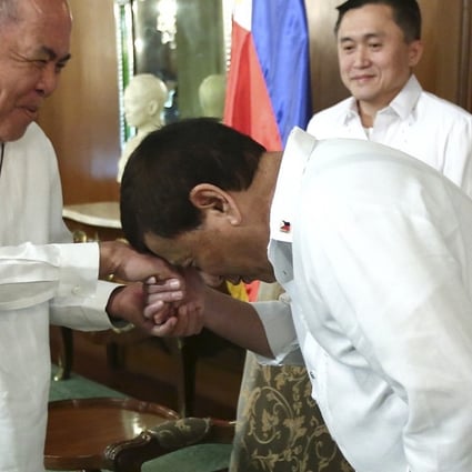Rodrigo Duterte bows to Filipino Archbishop Romulo Valles on Monday in Manila. Photo: Handout / AP