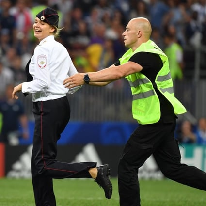 A member of Russian protest group Pussy Riot is grabbed by security after storming the pitch at the World Cup final between France and Croatia yesterday. Photo: AFP