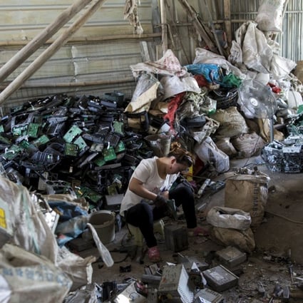 A worker recycles CD players at a workshop in Guiyu, a town notorious for its pollution problems. Photo: Reuters
