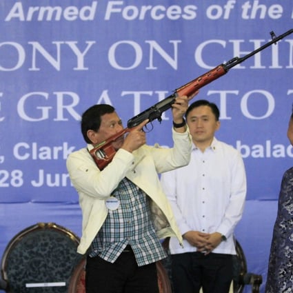 Philippine President Rodrigo Duterte checks a Chinese-made rifle during the ceremonial handover of military weapons from China to the Philippines inm 2017. File photo: EPA