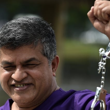 Malaysian political cartoonist Zulkiflee Anwar Haque, or Zunar, reacts with mock handcuffs during his case at Duta Court, in Kuala Lumpur, in April 2015. Photo: AFP