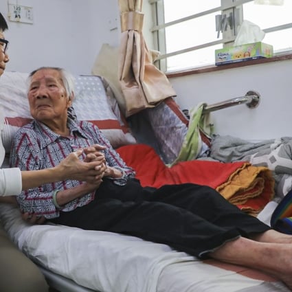 A woman visits her elderly mother in a care home in Tuen Mun. The demand for elderly care in Hong Kong outstrips the supply of affordable care options, and “ageing in place”, where elderly people live in their own homes, is seen as a solution. Photo: Edward Wong