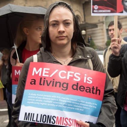A woman holds a sign for patients suffering from ME during “Millions Missing” rally in London. Those with the illness are known as the “missing millions”, as they have had to drop out of everyday life. Photo: Alamy