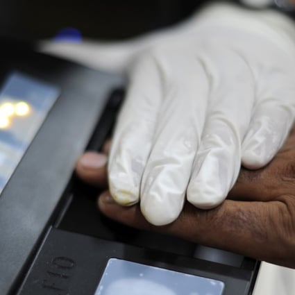 A foreign worker in Malaysia is scanned for a biometric ID at an immigration office. Those who fall foul of immigration rules have told of harsh treatment in holding cells. Photo: AFP