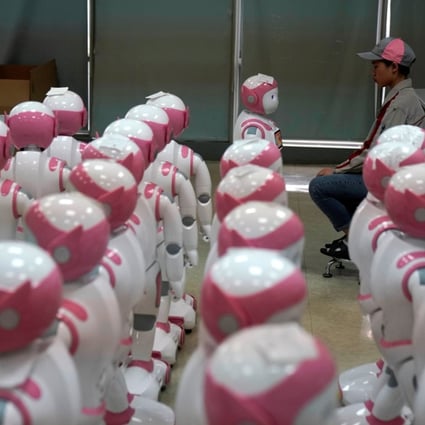 A worker faces an iPal robot, created by AvatarMind, at an assembly plant in Suzhou, Jiangsu province, China, on July 4. Designed to offer education, care and companionship to children and the elderly, the 3.5-feet tall humanoid robots come in two genders and can tell stories, take photos and deliver educational or promotional content. Photo: Reuters