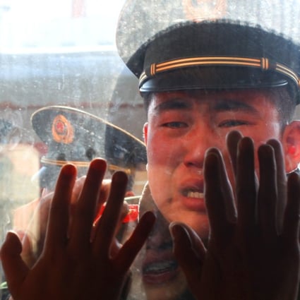 A PLA soldier bids adieu to his retired comrades at the railway station in Dandong, northeast China's Liaoning Province. Some soldiers who complete their military service are becoming drivers for Didi Chuxing. Photo: Xinhua