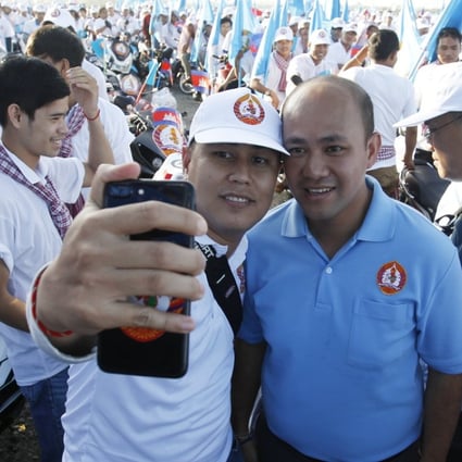 Like father, like son: Cambodian Prime Minister Hun Sen's son Hun Manet with a supporter of the Cambodian People's Party. Photo: EPA