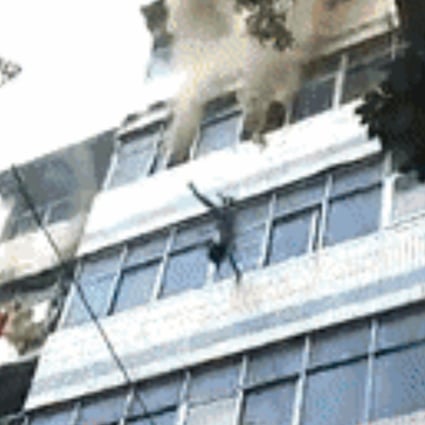 The child is thrown from the burning building, landing safely below. Photo: Handout
