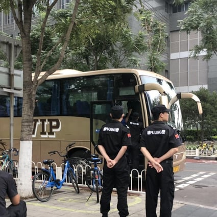 Police, plain clothes police and security personnel along with parked buses, are pictured at the Financial Street in downtown Beijing on 6 August, 2018. Photo:SCMP / Simon Song