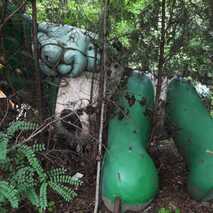 A Nini doll, one of five mascots for the 2008 Summer Olympics, lies among trees behind an abandoned mall in Beijing, on July 20, 2018, a decade after the Chinese capital hosted the Games. Picture: AFP