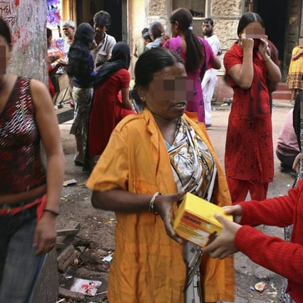 A volunteer (centre) distributes condoms to sex workers in Sonagachi, in the eastern Indian city of Kolkata. Photo: Reuters