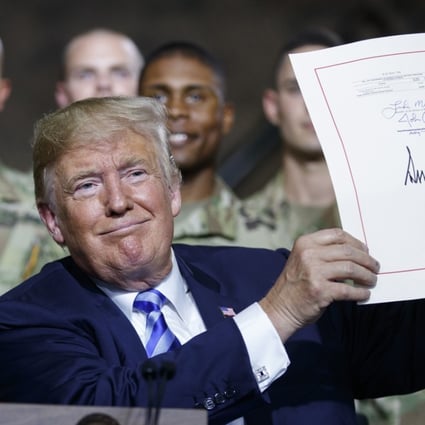 President Donald Trump signs the new US defence act on Monday. Photo: AP