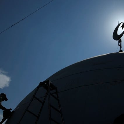 A worker paints the top of a mosque near Lamongan in East Java province. File photo: Reuters