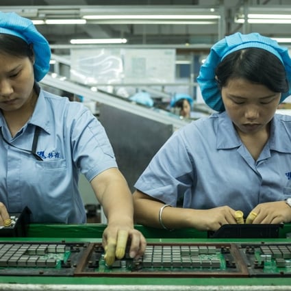 Employees mount cooling chips to circuit boards on an assembly line of cryptocurrency mining machines at Bitmain Technologies’ manufacturing base in Shenzhen. Photo: EPA