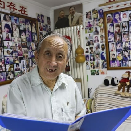 Zhu Fang browses through his files in a Beijing flat filled with photos of Chinese singles. Photo: Simon Song