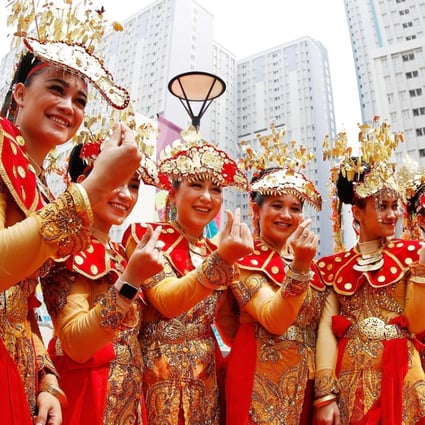 Etiquette team members in Indonesian folk costume at the Asian Games Village. Photo: Xinhua
