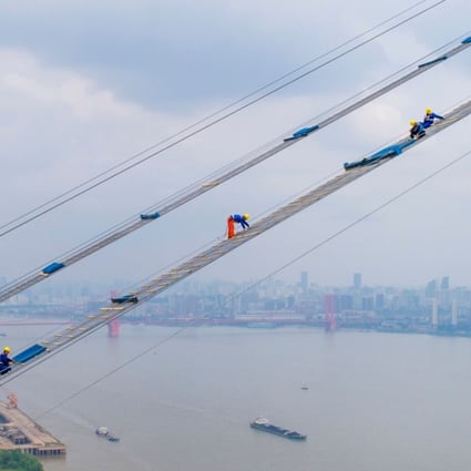 Construction workers help build a new bridge across the Yangtze in Wuhan city. Photo: AFP