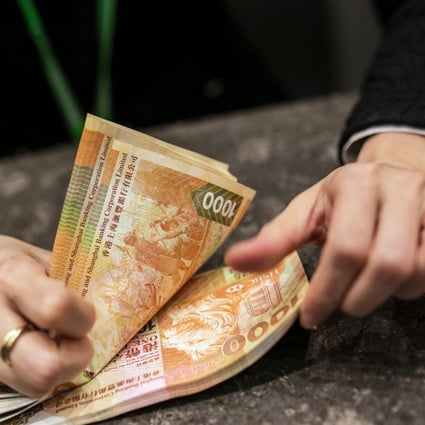 An employee counts HK$1,000 banknotes inside the Hang Seng Bank. Photo: Bloomberg