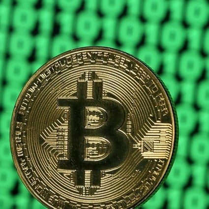 A token of the virtual currency Bitcoin is seen placed on a monitor that displays binary digits in this illustration picture. Photo: Reuters