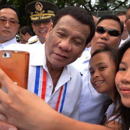 Philippines' President Rodrigo Duterte poses for a selfie with students this week in Manila. Photo: AFP