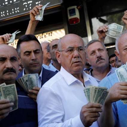 Businessmen holding US dollars stand in front of a currency exchange office in Ankara on August 14 in response to Turkish President Recep Tayyip Erdogan’s call to Turks to sell their dollar and euro savings to support the lira. Photo: Reuters