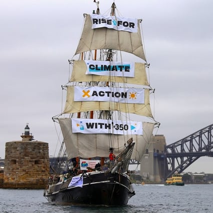 In Australia, a tall ship moved through Sydney Harbour in front of the Opera House as activists on board held up protest signs. Photo: Reuters