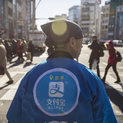A staff member wearing a uniform featuring the logo for Ant Financial Services Group's Alipay, at a campaign event in Tokyo on December 9. Photo: Bloomberg