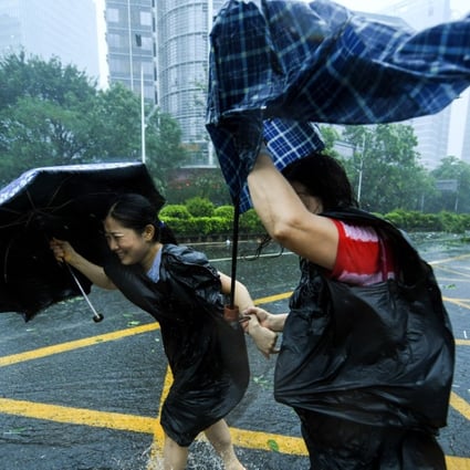 Two residents brave the wind in Shenzhen’s Nanshan district on Sunday. Photo: Xinhua