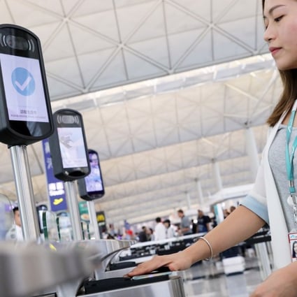 A member of staff demonstrates using an e-security gate at Hong Kong International Airport. Photo: K.Y. Cheng