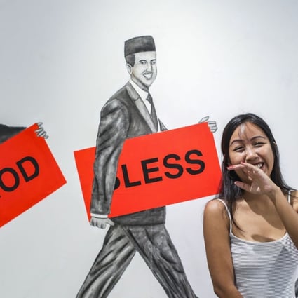 Malaysian artist Engku Iman poses in front of one of her works, portraying Muslim businessmen, at A2Z Art Gallery in Hong Kong. Photo: Xiaomei Chen