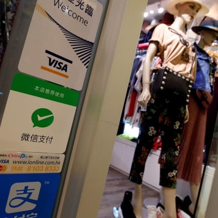 The Hong Kong version of the WeChat Pay mobile payment app, represented by the green tick sign, will soon be available for use to pay for purchases at mainland Chinese merchants. Photo: Reuters