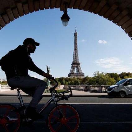 A commuter rides an e-bike from bike-sharing services provider Mobike at the Pont de Bir-Hakeim birdge, near the Eiffel Tower in Paris. Uber Technologies, which acquired US bicycle-rental service Jump Bikes in April, plans to introduce its bike-sharing service in Europe this fourth quarter. Photo: Reuters
