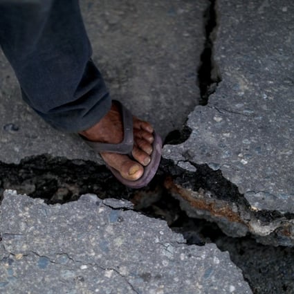 A man steps on a crack in a road at Balaroa neighbourhood hit by the earthquake and liquefaction in Palu, Central Sulawesi, Indonesia, on Wednesday. The country was struck by a second earthquake on Wedneday. Photo: Reuters