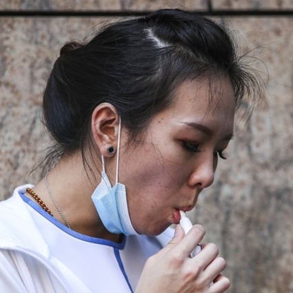 A woman smokes an electronic cigarette in Mong Kok. If Hong Kong goes ahead with its ban on e-cigarettes, it will join more than a dozen other countries that have done the same. Photo: Edward Wong