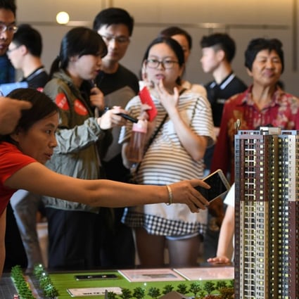 A woman points at the model of a residential compound by China Vanke during the Golden Week holiday in Dongguan. Photo: Reuters