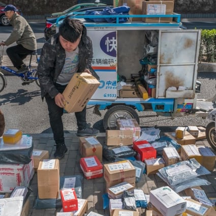 A courier stacks parcels by the roadside in Beijing, China in 2017. Photo: Alamy