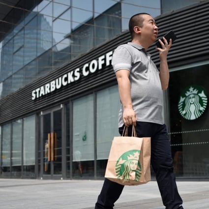 A man walks past a Starbucks coffee shop in Beijing on August 2, 2018. Starbucks on August 2 announced a partnership with e-commerce giant Alibaba that will give the US coffee giant greater access to China's growing food-delivery market as it faces increased competition from local firms. Photo: AFP