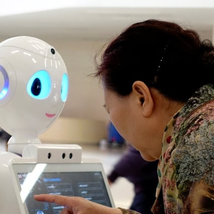 A woman touches a screen on a robot developed by iFlyTek at the outpatient hall of People's Liberation Army General Hospital in Beijing. Natural language processing has been considered one of the holy grails in AI. Photo: Reuterss