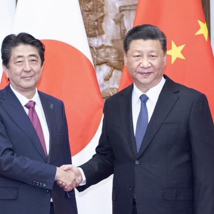 Chinese President Xi Jinping (right) shakes hands with visiting Japanese Prime Minister Shinzo Abe in Beijing on Friday. Photo: Xinhua