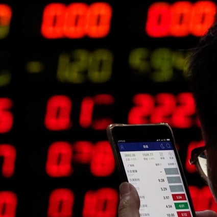 An investor checks stock information on a mobile phone at a brokerage house in Shanghai on June 20, 2018. Photo: Aly Song