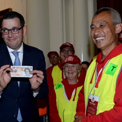 Victorian Premier Daniel Andrews holds a British ten pound note at a function to formally apologise to descendants of Chinese migrants who were targeted by a racist ten pound tax some 160 years ago. Photo: EPA
