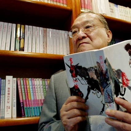 Novelist Louis Cha holding a copy of ‘Book and Sword, Gratitude and Revenge’ at his office in 2002. Photo: Reuters