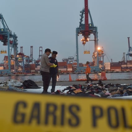 Indonesian policemen examining debris of the ill-fated Lion Air flight. Photo: AFP