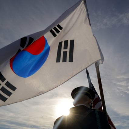 A member of the Honour Guard carries the South Korean flag. Photo: AP