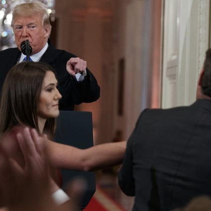 US President Donald Trump watches as a White House aide reaches to take away a microphone from Jim Acosta of CNN during a news conference in Washington on November 7. CNN is suing the Trump administration, demanding that Acosta’s press credentials to cover the White House be restored. Photo: AP