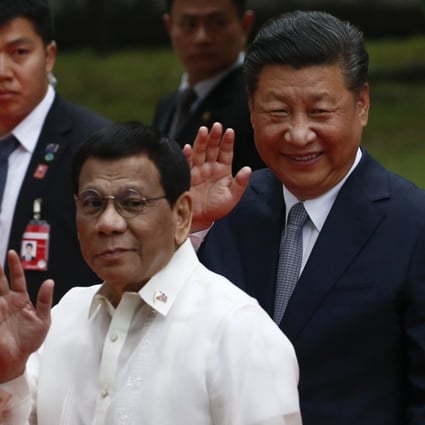 Rodrigo Duterte and Xi Jinping wave during a welcome ceremony at Malacanang Palace in Manila on Tuesday. Photo: EPA-EFE