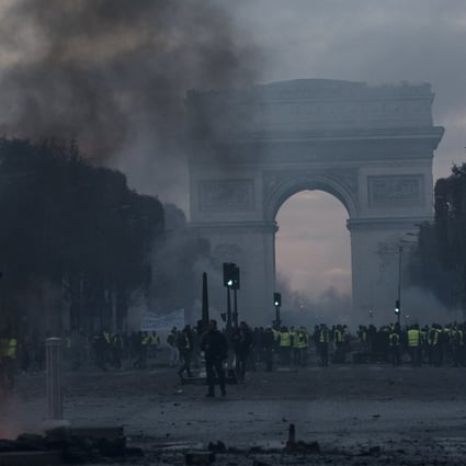 As night fell, the famed Champs-Elysees avenue, where fashion designer Karl Lagerfeld switched on the red lights of Christmas just a few days ago, was still aglow with fires lit by protesters. Photo: EPA